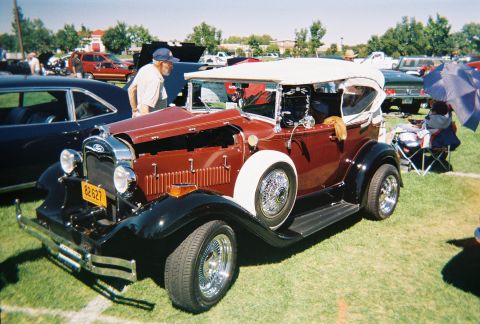 1972 Ford Ranchero - A classic Ford Model A Roadster is displayed at an outdoor car show with other vehicles in the background.
