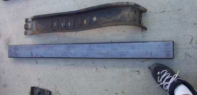 1995 Ford Bronco - Two automotive frame parts are shown on a concrete surface.