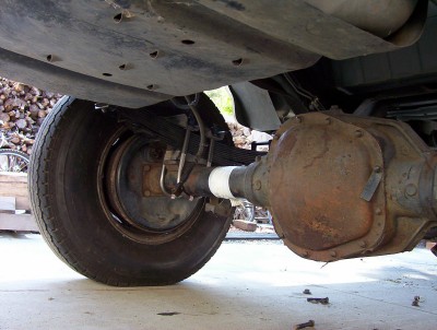 1995 Ford Bronco - Close-up of a vehicle's rear axle and suspension components, showing rust and wear.