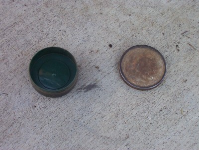 1995 Ford Bronco - Two round metal caps, one green and one rusty, are shown on a concrete surface.
