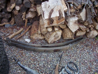 1995 Ford Bronco - Leaf springs are shown in front of a pile of firewood.