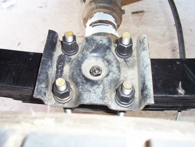 1995 Ford Bronco - Close-up of a vehicle's leaf spring and U-bolt suspension component.