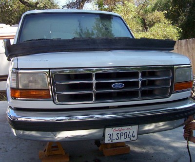 1995 Ford Bronco - Front view of a white Ford truck, possibly an F-150, with a chrome grille and California plates.