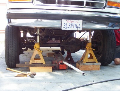 1995 Ford Bronco - Front view of a Ford truck supported by jack stands, revealing its undercarriage and suspension components.