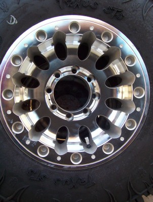 1995 Ford Bronco - Close-up of a custom aluminum wheel mounted on a tire, with "SUPERMOTORS" branding visible at the bottom.