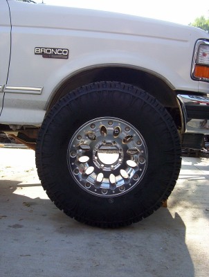 1995 Ford Bronco - Close-up of a 1995 Ford Bronco's front fender and wheel assembly.
