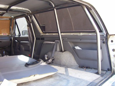 1995 Ford Bronco - The interior of a 1995 Ford Bronco shows a custom roll cage and the removed rear seat.