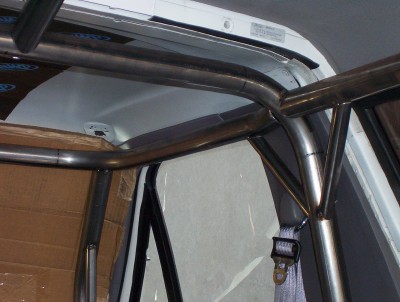 1995 Ford Bronco - The interior of a vehicle shows a custom roll cage installation.