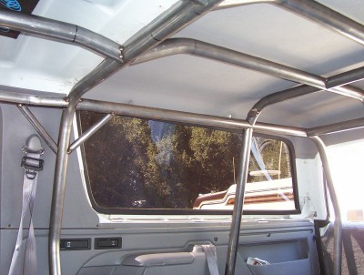 1995 Ford Bronco - Custom roll cage installed inside a vehicle, with a view through the rear window.