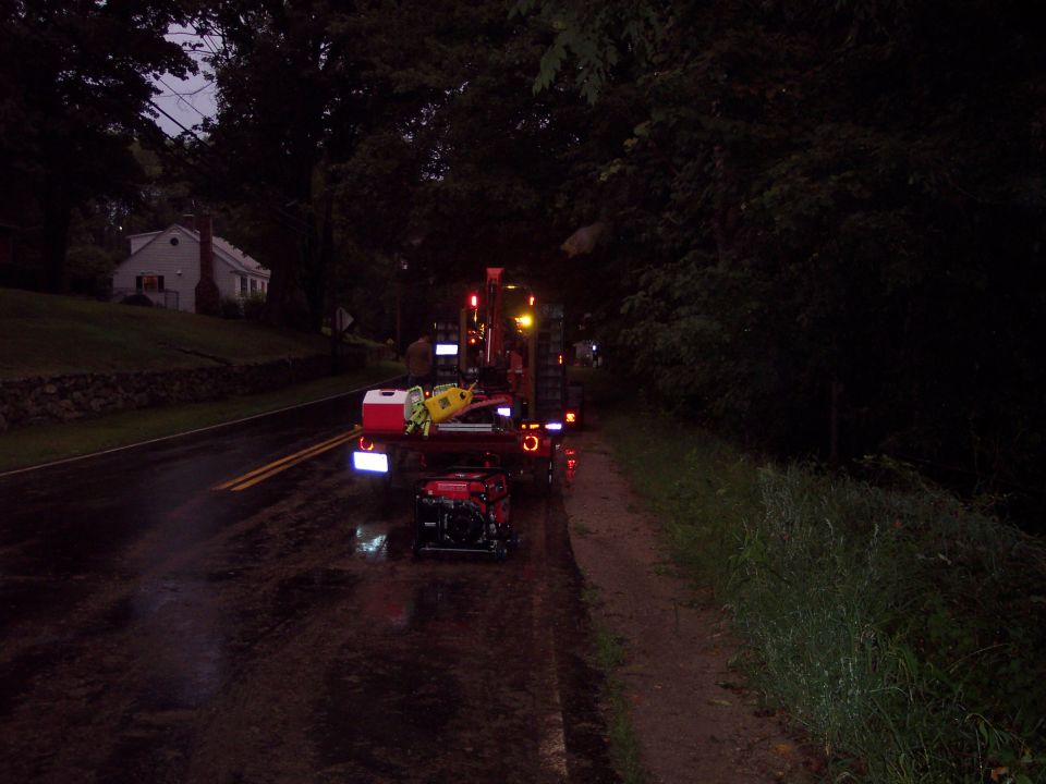 Trailer with red and yellow equipment on a wet road at night