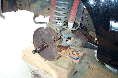 1995 Ford Bronco - A front hub torn down on a lifted 4x4: the wheel, hub and locking hub are off, leaving the splined axle shaft stub sticking out through the…