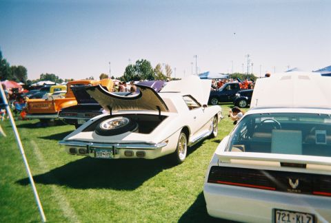 1972 Ford Ranchero - A white coupe with its trunk open, displaying a spare tire, at an outdoor car show.