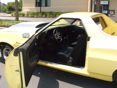 1972 Ford Ranchero - Interior view of a yellow 1972 Ford Ranchero, bucket seats and an aftermarket steering wheel.