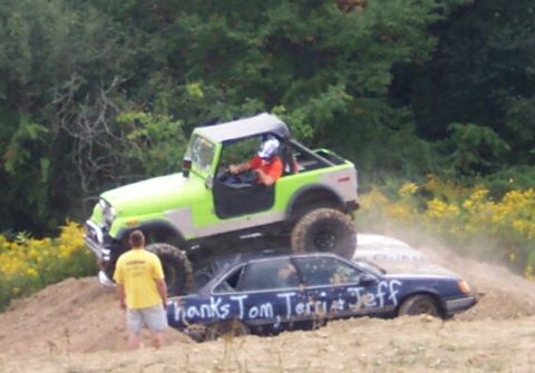 1979 Ford F-150 - A Jeep is driven over a sedan that has names written on its doors.