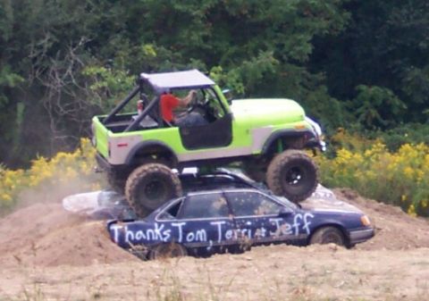 1979 Ford F-150 - An off-road vehicle is driven over a sedan that has been written on with white paint.