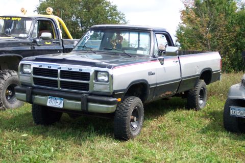 1979 Ford F-150 - This Dodge Ram pickup truck is parked on a grassy field next to another vehicle.