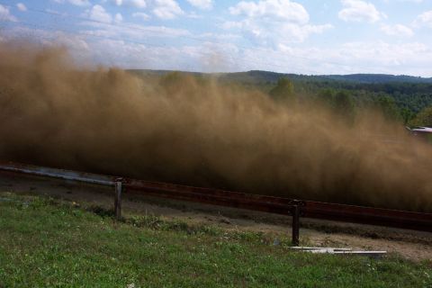 1979 Ford F-150 - A vehicle is obscured by a large dust cloud on a sunny day.