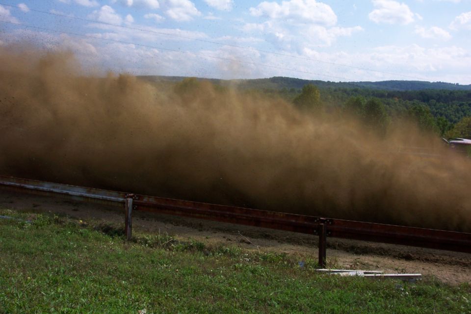 dust cloud kicked up by a vehicle on a dirt road