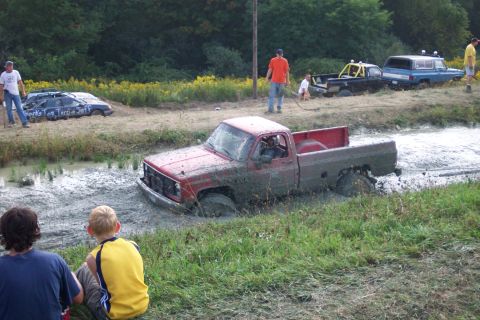 1979 Ford F-150 - Several vehicles are stuck in the mud during an off-road event.