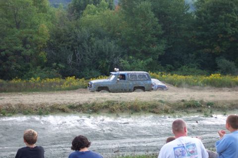 1979 Ford F-150 - Two vehicles are stuck in the mud during a bogging event, with onlookers observing the scene.