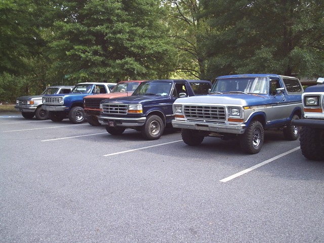 Several Ford Broncos parked in a lot, including a 1978 model in the foreground