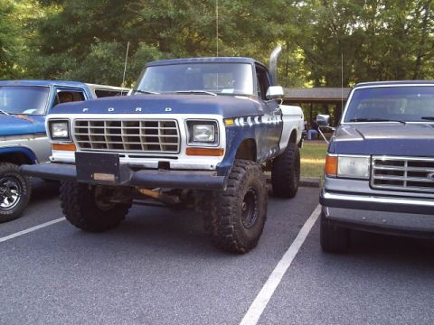 1989 Ford Bronco - This lifted Ford pickup truck has a distinctive grille and exhaust stack, suggesting an older model year.