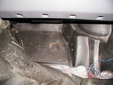 1992 Ford Taurus - Close-up view of the subframe recall kit hole location within the vehicle's interior.