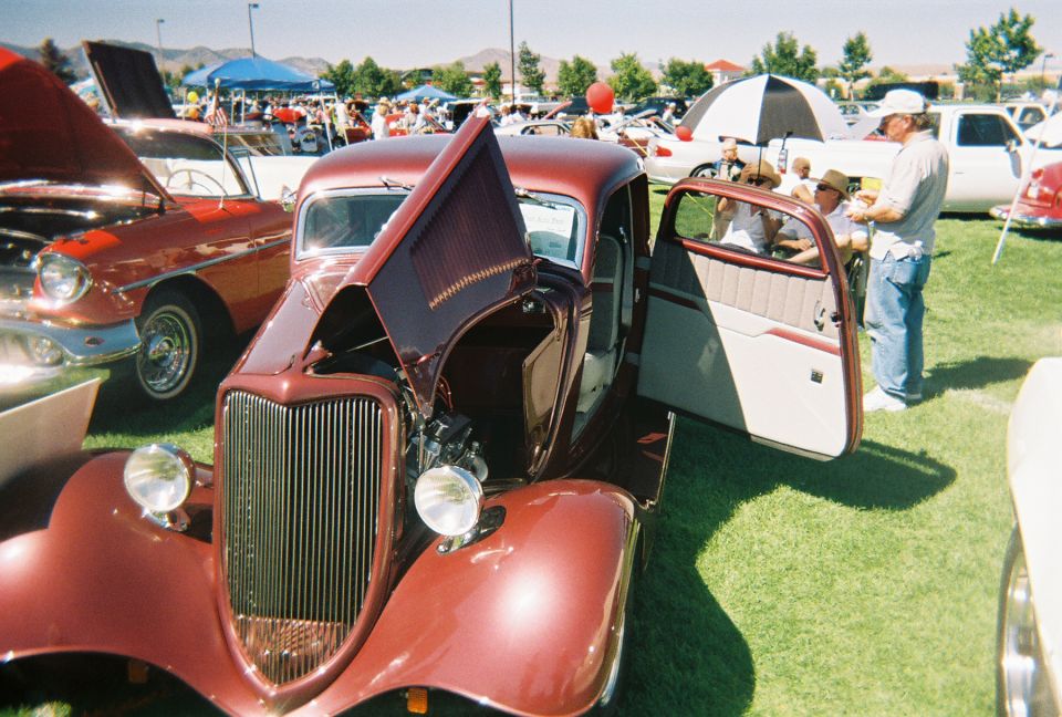 Maroon hot rod with hood and door open, showing engine and interior