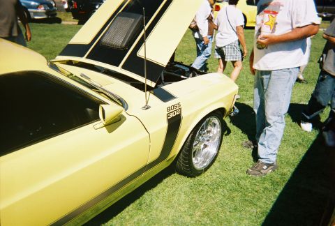 1972 Ford Ranchero - A yellow muscle car, identified by its 'BOSS 302' badging and racing stripes, is displayed with its hood open.