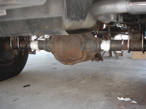 1978 Ford Bronco - Close-up of a vehicle's rear axle assembly, showing rust and some white tape on the driveshaft.