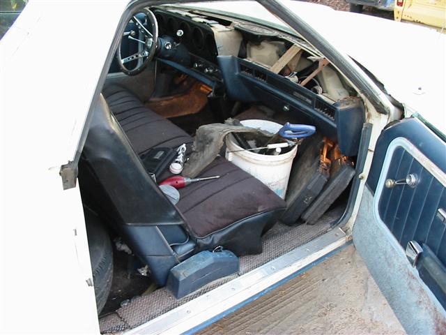 Interior of a 1974 Ford Ranchero showing blue seats, dashboard, and tools