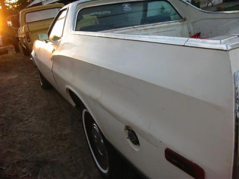 1974 Ford Ranchero - A white 1972 Ford Ranchero is parked next to a yellow truck during sunset.