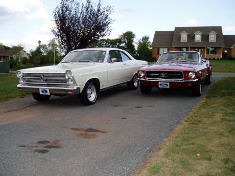 1967 Ford Mustang - Two classic Ford cars, a red 1967 Mustang convertible and a white Fairlane, are parked on a suburban driveway.