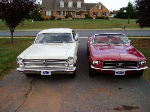 1967 Ford Mustang - A red 1967 Ford Mustang convertible is parked next to a white sedan in front of a suburban home.