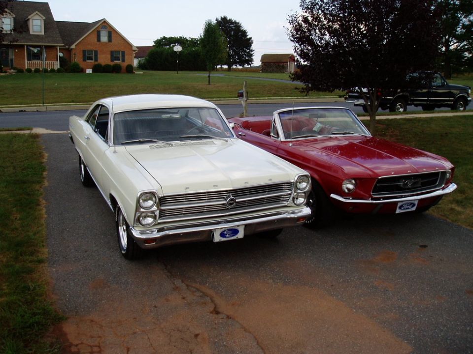 1967 Ford Mustang convertible next to a white Ford Fairlane coupe