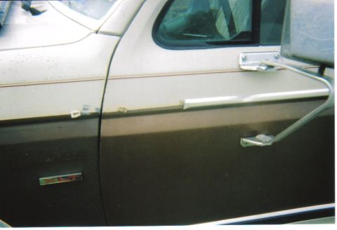 1982 Ford Bronco - Close-up of the side door on a 1982 Ford Bronco, showing its two-tone paint scheme.