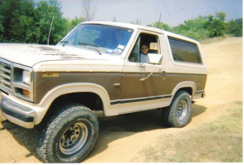 1982 Ford Bronco - This two-tone brown and white SUV is captured from a 3/4 front angle, appearing to be from the early 1980s.