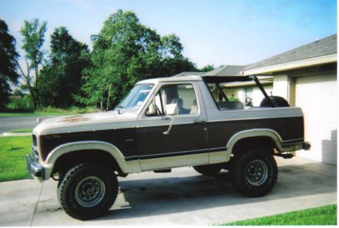 1982 Ford Bronco - This two-tone Ford Bronco, likely from the early 1980s, is parked in front of a garage.