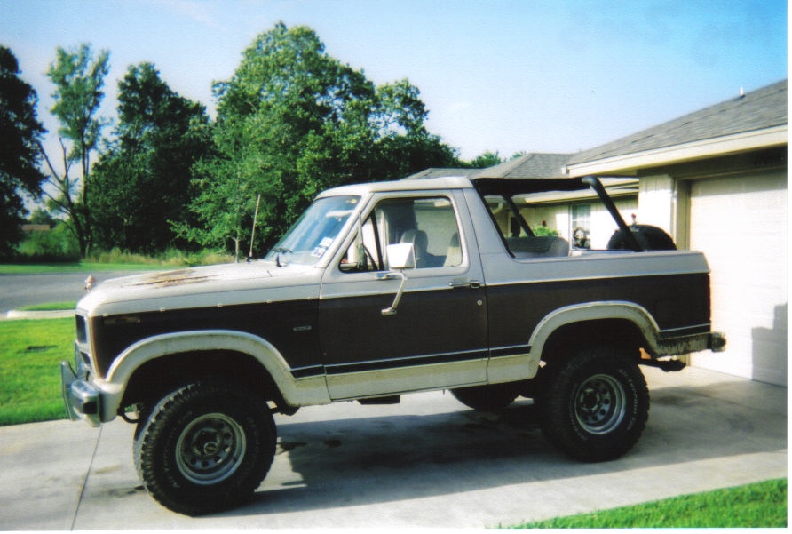Two-tone brown and beige Ford Bronco with aftermarket wheels and tires parked on a driveway