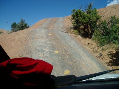 2000 Ford E350 - The view from inside a vehicle driving up a steep, rocky trail marked with yellow paint.