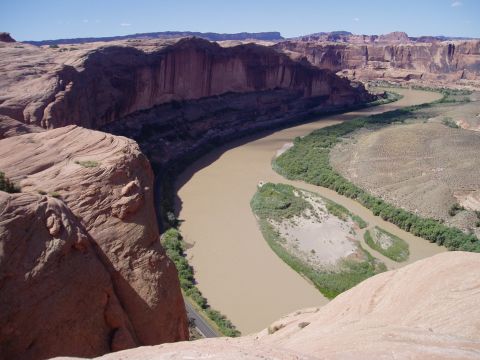 2000 Ford E350 - A scenic view of a river flowing through a vast canyon landscape under a clear blue sky.