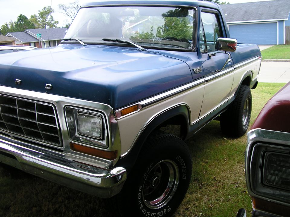 Blue and tan two-tone late-70s Ford pickup or Bronco front corner with chrome grille and round headlights