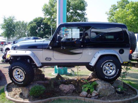 2000 Ford E350 - This Jeep Wrangler is displayed on a rock formation, showing off its off-road tires and two-tone paint scheme.