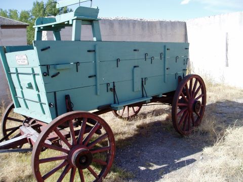 2000 Ford E350 - A vintage horse-drawn wagon with wooden construction and spoked wheels sits outdoors.