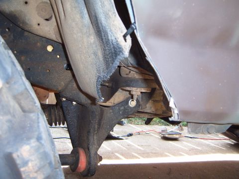 1988 Ford Bronco - Detail of vehicle undercarriage, showing suspension components and part of the frame.