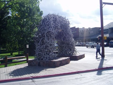 2000 Ford E350 - A large archway sculpture made of antlers stands in a town square, with a white pickup truck and pedestrians in the background.