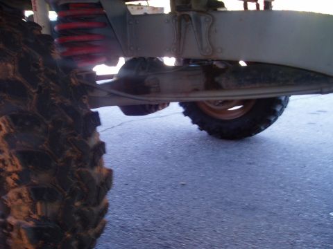 2000 Ford E350 - Close-up view of the undercarriage and large tires of a vehicle, showing suspension parts.