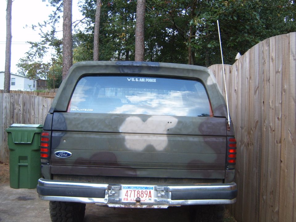 Rear view of a 1988 Ford Bronco with camouflage paint and a 'U.S. AIR FORCE' sticker on the back window