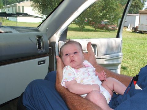 1966 Ford Ranchero - A baby is held inside a vehicle with the door open, revealing an outdoor scene.