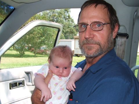 1966 Ford Ranchero - Man holds baby inside vehicle interior with open door showing outdoor scene.